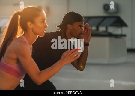 Couple de fitness se préparant à courir au coucher du soleil sur le toit Banque D'Images