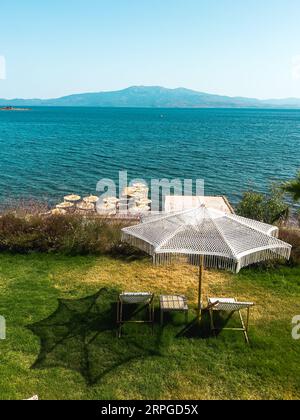 Deux chaises longues sur l'herbe avec parasol, chaises longues vides avec le concept d'application environnementale Seaascape. Photo de haute qualité Banque D'Images