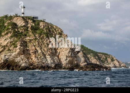 Vue sur la côte rocheuse et le phare de la Bufadora, à Huatulco, Oaxaca, Mexique. Plage touristique au Mexique. Banque D'Images