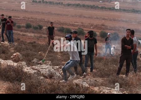 191017 -- RAMALLAH, 17 octobre 2019 Xinhua -- un manifestant palestinien utilise une fronde pour lancer des pierres sur des soldats israéliens lors d’affrontements qui ont suivi une manifestation contre la construction d’un avant-poste israélien près du village de Turmus Ayya et de la colonie israélienne de Shilo, au Nord de la ville de Ramallah en Cisjordanie, le 17 octobre 2019. Photo de Nidal Eshtayeh/Xinhua MIDEAST-RAMALLAH-AFFRONTEMENTS PUBLICATIONxNOTxINxCHN Banque D'Images