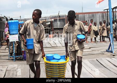 191018 -- COTONOU, le 18 octobre 2019 -- des élèves portent des sets de riz pour le déjeuner à l'école primaire Toyoyome, dans la banlieue de Cotonou, Bénin, le 17 octobre 2019. Abdoulaye Bio-Tchane, ministre d'État béninois chargé de la planification et du développement, a déclaré que la Chine était le principal partenaire du programme intégré d'alimentation scolaire de ce pays d'Afrique de l'Ouest visant à améliorer les taux de scolarisation et de rétention scolaire des enfants. TO GO WITH Interview : le programme d'alimentation scolaire aidé par la Chine apporte des résultats favorables au Bénin : photo officielle par /Xinhua BÉNIN-COTONOU-CHINE PROGRAMME D'ALIMENTATION SCOLAIRE AIDÉ PAR la CHINE SeraphinxZounyekpe PUBLICATIONxNOTxINxCHN Banque D'Images