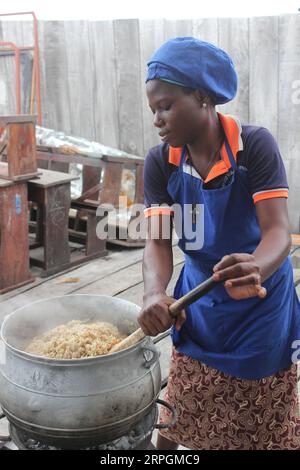 191018 -- COTONOU, le 18 octobre 2019 -- un membre du personnel d'une cantine prépare un déjeuner avec du riz aidé par la Chine à l'école primaire Toyoyome dans la banlieue de Cotonou, Bénin, le 17 octobre 2019. Abdoulaye Bio-Tchane, ministre d'État béninois chargé de la planification et du développement, a déclaré que la Chine était le principal partenaire du programme intégré d'alimentation scolaire de ce pays d'Afrique de l'Ouest visant à améliorer les taux de scolarisation et de rétention scolaire des enfants. TO GO WITH Interview : le programme d'alimentation scolaire aidé par la Chine apporte des résultats favorables au Bénin : photo officielle par /Xinhua BÉNIN-COTONOU-CHINE PROGRAMME D'ALIMENTATION SCOLAIRE AIDÉ PAR SeraphinxZounyekpe Banque D'Images