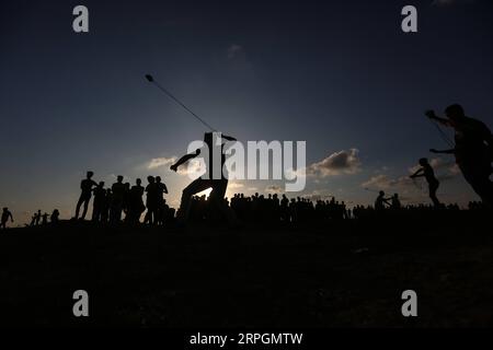 191019 -- GAZA, le 19 octobre 2019 -- Un manifestant palestinien utilise une fronde pour lancer des pierres sur les troupes israéliennes lors d'affrontements à la frontière Gaza-Israël, à l'est de la ville de Gaza, le 18 octobre 2019. Au moins 69 Palestiniens ont été blessés vendredi par des tirs de soldats israéliens lors d'affrontements avec des dizaines de manifestants palestiniens dans l'est de la bande de Gaza, près de la frontière avec Israël, ont déclaré des médecins. Photo de /Xinhua MIDEAST-GAZA-AFFRONTEMENTS MohammedxDahman PUBLICATIONxNOTxINxCHN Banque D'Images