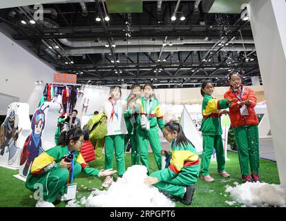 191020 -- BEIJING, le 20 octobre 2019 -- des élèves jouent à la neige produite par une machine à neige à l'exposition World Winter Sports Beijing 2019 à Beijing, capitale de la Chine, le 17 octobre 2019. Xinhua Headlines : l'industrie des sports d'hiver relie la Chine et le monde JuxHuanzong PUBLICATIONxNOTxINxCHN Banque D'Images