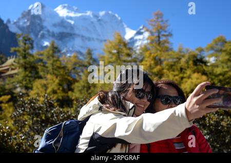 191021 -- DAOCHENG, le 21 octobre 2019 -- des touristes prennent des photos dans le site pittoresque de Yading, dans le comté de Daocheng de la préfecture autonome tibétaine de Garze, dans le sud-ouest de la Chine, dans la province du Sichuan, le 20 octobre 2019. Photo de /Xinhua CHINA-SICHUAN-DAOCHENG- DÉCOR D'AUTOMNE CN TangxWenhao PUBLICATIONxNOTxINxCHN Banque D'Images