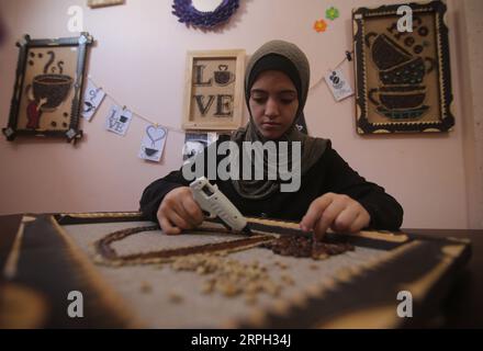 191028 -- GAZA, 28 octobre 2019 -- l'artiste palestinienne Hala Abu Qaoud fabrique des œuvres d'art en utilisant des grains de café chez elle, dans la ville de Rafah, dans le sud de la bande de Gaza, le 28 octobre 2019. Abu Qaoud, 20 ans, étudie les beaux-arts dans une université locale de Gaza. Elle vend ses œuvres d'art sur les plateformes de médias sociaux. Photo de /Xinhua MIDEAST-GAZA-ART KhaledxOmar PUBLICATIONxNOTxINxCHN Banque D'Images