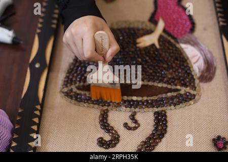 191028 -- GAZA, 28 octobre 2019 -- l'artiste palestinienne Hala Abu Qaoud fabrique des œuvres d'art en utilisant des grains de café chez elle, dans la ville de Rafah, dans le sud de la bande de Gaza, le 28 octobre 2019. Abu Qaoud, 20 ans, étudie les beaux-arts dans une université locale de Gaza. Elle vend ses œuvres d'art sur les plateformes de médias sociaux. Photo de /Xinhua MIDEAST-GAZA-ART KhaledxOmar PUBLICATIONxNOTxINxCHN Banque D'Images