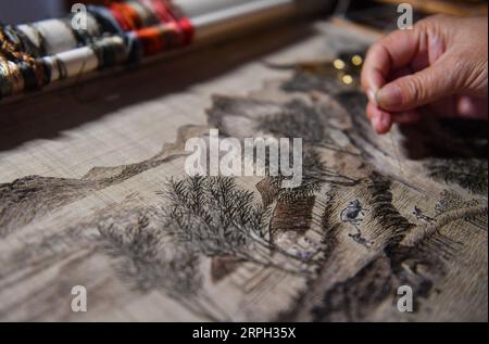 191028 -- NANCHANG, 28 octobre 2019 -- Zhang Xiaohong broie dans son atelier de Xinyu City, province du Jiangxi, dans l'est de la Chine, le 23 octobre 2019. Datant de la dynastie des Song du Nord 960-1127, Xiabu, ou lin d'herbe, est une sorte de tissu fabriqué à partir de ramie. Zhang Xiaohong, 61 ans, est un héritier représentant national de la broderie Xiabu. En 2002, elle crée un atelier de broderie dans sa ville natale de Xinyu après avoir étudié à Tianjin et Suzhou. Au fil des ans, Zhang a mis à jour la qualité du tissu et a également créé six façons de points. En 2014, elle a été reconnue comme représentante nationale Banque D'Images