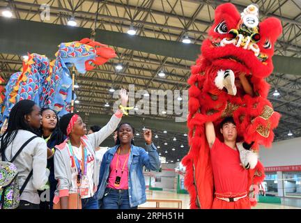 191030 -- ZHENGZHOU, 30 octobre 2019 -- Raissa 3rd L regarde une performance de danse du lion à l'Université Sisa de Zhengzhou, province du Henan en Chine centrale, 28 octobre 2019. Raissa, dix-sept ans, est née et a grandi aux Comores, un pays insulaire de l’océan Indien. En 2016, la grand-mère de Raissa a été guérie par les médecins de l équipe médicale chinoise en Afrique. Raissa développe alors un lien émotionnel fort avec la Chine, ce qui l'incite à apprendre le chinois à l'Institut Confucius local avec des efforts inlassables. Sur le concours préliminaire de la 12e compétition de compétence de pont chinois pour la deuxième Banque D'Images