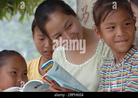 191031 -- PÉKIN, le 31 octobre 2019 -- une photo prise le 29 juillet 2004 montre Zhou Biaoliang et ses élèves à l'école primaire Hope du comté de Pingguo dans la ville de baise, dans le sud-ouest de la Chine, dans la région autonome de Guangxi Zhuang. Zhou termine ses études avec l'aide du projet Hope. Après avoir obtenu son diplôme, elle est retournée à son école primaire pour être enseignante en retour. Project Hope, un programme chinois visant à financer l’éducation des étudiants touchés par la pauvreté, célèbre son 30e anniversaire le 30 octobre 2019. Le projet a été initié par la Fondation chinoise pour le développement de la jeunesse CYDF et la COM centrale Banque D'Images