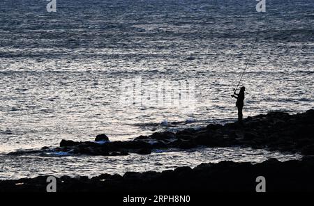 191102 -- PÉKIN, le 2 novembre 2019 -- Un homme pêche au bord de la mer au crépuscule à Magong, comté de Penghu, dans le sud-est de la Chine, Taiwan, le 1 novembre 2019. PHOTOS XINHUA DU JOUR ChenxBin PUBLICATIONxNOTxINxCHN Banque D'Images