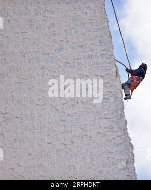191106 -- LHASSA, 6 novembre 2019 Xinhua -- Un ouvrier participe au blanchissage de l'extérieur du palais du Potala à Lhassa, dans la région autonome du Tibet du sud-ouest de la Chine, le 1 novembre 2019. Chaque année, des ouvriers et des centaines de bénévoles locaux se réunissent au palais du Potala à Lhassa pour donner un coup de fouet à l'ancien palais. Le palais vieux de 1 300 ans est un point de repère de Lhassa. Il a accueilli 1,45 millions de touristes en 2017. Le palais a été inscrit sur la liste du patrimoine mondial de l'UNESCO en 1994. Il faut généralement environ une douzaine de jours pour peindre le palais en préparation du prochain Lhabab Duchen, qui est cru t Banque D'Images