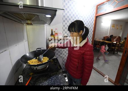 191107 -- LUOCHENG, 7 novembre 2019 -- Pang Shuidi, épouse de Wu Caizhong, cuisine dans sa nouvelle maison du comté de luocheng, dans la région autonome de Guangxi Zhuang, dans le sud de la Chine, le 6 novembre 2019. Wu Caizhong est une ethnie Mulao âgée de 36 ans. Sa famille, avec d'autres Mulao, vivait à Xiayantun du village de Mianhua, un village en proie à un développement inadéquat en raison de la désertification rocheuse karstique et des mauvaises conditions de circulation. En juin 2018, la famille Wu et d autres villageois ont été relogés dans un nouveau quartier résidentiel pour les Mulao à luocheng. Ce quartier résidentiel, avec de multiples supports fa Banque D'Images