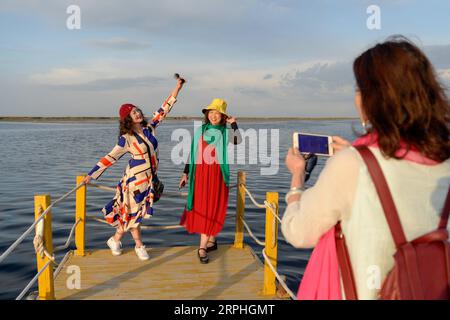 191108 -- URUMQI, 8 novembre 2019 -- des touristes posent pour des photos avec le lac Bosten dans le comté de Bohu, dans la région autonome ouïgoure du Xinjiang, au nord-ouest de la Chine, le 12 octobre 2019. Le nombre de touristes dans la région autonome ouïgoure du Xinjiang du nord-ouest de la Chine a dépassé les 200 millions de janvier à octobre de cette année, en hausse de 42,62 pour cent d'une année sur l'autre, selon les autorités locales. CHINE-XINJIANG-TOURISME CN DingxLei PUBLICATIONxNOTxINxCHN Banque D'Images