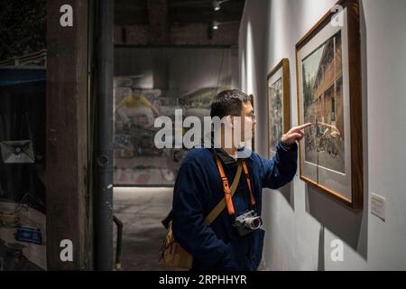 191109 -- BEIJING, le 9 novembre 2019 -- Liu Gaochao montre une photo en visitant une exposition dans la zone artistique 798 à Beijing, capitale de la Chine, le 9 novembre 2019. Cela fait plus de cinq ans que Liu Gaochao a embrassé une carrière dans le développement cinématographique. Au sommet d'un manoir de grande hauteur à côté de la station Liufang de la ligne 13 du métro de Pékin, Liu gère un studio, New Wave film Lab, qui lui fournit également un endroit où vivre. En 2012, Liu a quitté sa ville natale dans la province du Henan au centre de la Chine et s est dirigé vers Pékin à la recherche de meilleures opportunités. Après s'être installé dans la capitale, il est tombé sur film photogra Banque D'Images