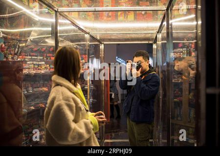 191109 -- PÉKIN, le 9 novembre 2019 -- Liu Gaochao prend des photos d'un ami dans la zone artistique 798 à Pékin, capitale de la Chine, le 9 novembre 2019. Cela fait plus de cinq ans que Liu Gaochao a embrassé une carrière dans le développement cinématographique. Au sommet d'un manoir de grande hauteur à côté de la station Liufang de la ligne 13 du métro de Pékin, Liu gère un studio, New Wave film Lab, qui lui fournit également un endroit où vivre. En 2012, Liu a quitté sa ville natale dans la province du Henan au centre de la Chine et s est dirigé vers Pékin à la recherche de meilleures opportunités. Après s'être installé dans la capitale, il est tombé sur la photographie de film et est tombé pour le A. Banque D'Images