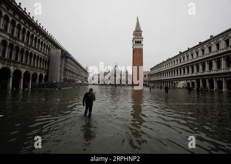 191114 -- VENISE, 14 novembre 2019 Xinhua -- Un homme traverse la place Saint-Marc inondée à Venise, Italie, le 13 novembre 2019. Les habitants de la ville inondée de Venise réclament l'achèvement d'un ambitieux plan de protection contre les inondations, élaboré il y a des décennies, malgré les inquiétudes des groupes environnementaux quant au fait que le plan pourrait causer des dommages écologiques à la région environnante. Les eaux de crue dans la ville du nord de l'Italie cette semaine ont atteint jusqu'à 187 centimètres, le plus haut niveau depuis l'inondation historique de 1966. Photo Alberto Lingria/Xinhua ITALY-VENICE-FLOOD PUBLICATIONxNOTxINxCHN Banque D'Images