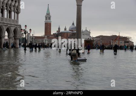 191114 -- VENISE, 14 novembre 2019 Xinhua -- les gens traversent la place Saint-Marc inondée à Venise, Italie, 13 novembre 2019. Les habitants de la ville inondée de Venise réclament l'achèvement d'un ambitieux plan de protection contre les inondations, élaboré il y a des décennies, malgré les inquiétudes des groupes environnementaux quant au fait que le plan pourrait causer des dommages écologiques à la région environnante. Les eaux de crue dans la ville du nord de l'Italie cette semaine ont atteint jusqu'à 187 centimètres, le plus haut niveau depuis l'inondation historique de 1966. Photo Alberto Lingria/Xinhua ITALY-VENICE-FLOOD PUBLICATIONxNOTxINxCHN Banque D'Images