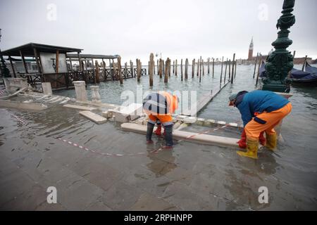 191114 -- VENISE, 14 novembre 2019 Xinhua -- des travailleurs nettoient la clôture endommagée par une inondation près de la place Saint-Marc à Venise, Italie, 13 novembre 2019. Les habitants de la ville inondée de Venise réclament l'achèvement d'un ambitieux plan de protection contre les inondations, élaboré il y a des décennies, malgré les inquiétudes des groupes environnementaux quant au fait que le plan pourrait causer des dommages écologiques à la région environnante. Les eaux de crue dans la ville du nord de l'Italie cette semaine ont atteint jusqu'à 187 centimètres, le plus haut niveau depuis l'inondation historique de 1966. Photo Alberto Lingria/Xinhua ITALY-VENICE-FLOOD PUBLICATIONxNOTx Banque D'Images