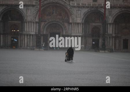 191114 -- VENISE, 14 novembre 2019 Xinhua -- Un homme traverse la place Saint-Marc inondée à Venise, Italie, le 13 novembre 2019. Les habitants de la ville inondée de Venise réclament l'achèvement d'un ambitieux plan de protection contre les inondations, élaboré il y a des décennies, malgré les inquiétudes des groupes environnementaux quant au fait que le plan pourrait causer des dommages écologiques à la région environnante. Les eaux de crue dans la ville du nord de l'Italie cette semaine ont atteint jusqu'à 187 centimètres, le plus haut niveau depuis l'inondation historique de 1966. Photo Alberto Lingria/Xinhua ITALY-VENICE-FLOOD PUBLICATIONxNOTxINxCHN Banque D'Images