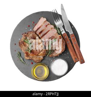 Morceaux de délicieuse viande frite servis avec romarin, huile et épices sur fond blanc, vue de dessus Banque D'Images