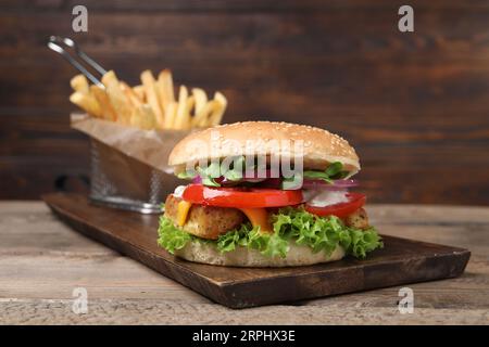 Délicieux Burger au tofu servi avec des frites sur une table en bois Banque D'Images