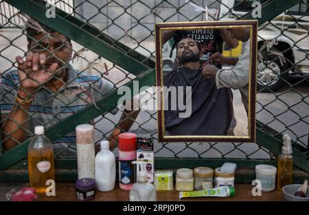 191122 -- PÉKIN, le 22 novembre 2019 -- Un homme regarde un barbier en bord de route tondre la barbe de son client à New Delhi, Inde, le 21 novembre 2019. PHOTOS XINHUA DU JOUR JavedxDar PUBLICATIONxNOTxINxCHN Banque D'Images