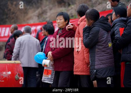 191122 -- COMTÉ DE YICHENG, 22 novembre 2019 -- des villageois attendent dans les files d'attente pour recueillir de l'eau après qu'un puits en eau profonde ait commencé à pomper de l'eau souterraine dans le village de Nanling du comté de Yicheng, le 20 novembre 2019. Lorsque l'interrupteur a été tiré, l'eau a jailli de 403 mètres plus bas. Le tout premier puits en eau profonde de Nanling Village a été mis en service un matin tôt d hiver. Dans le passé, le village, qui s’étendait à travers les ravins des montagnes Zhongtiao dans le nord de la Chine, dépendait uniquement des fosses à boue pour stocker sa précieuse eau potable depuis des siècles. Hantées par la peur de la sécheresse, des générations avaient rêvé Banque D'Images