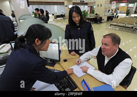 191201 -- YIWU, décembre 1, 2019 -- les membres du personnel servent le marchand britannique Taishan R à un centre de service commercial international à Yiwu, province de Zhejiang de l'est de la Chine, novembre 29, 2019. En 2005, Nigel Cropp, un homme britannique, est venu à Yiwu petit marché de marchandises dans la province de Zhejiang de l'est de la Chine pour enseigner l'anglais aux marchands ici. Il a pris Taishan comme nom chinois parce qu'il donne toujours aux gens l'impression d'être aussi stable que le mont Taishan. En 2008, Taishan épouse son élève Wu Qinyan. Cette année-là, Taishan a mis en pratique les connaissances en marketing qu’il avait apprises à l’université et a fondé son propre imp Banque D'Images