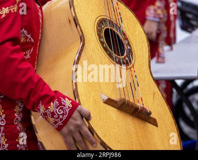 Gros plan d'une femme mariachi méconnaissable portant le costume traditionnel de charra, tenant un mariachi Guitarrón Mexicano (grosse guitare mexicaine) Banque D'Images