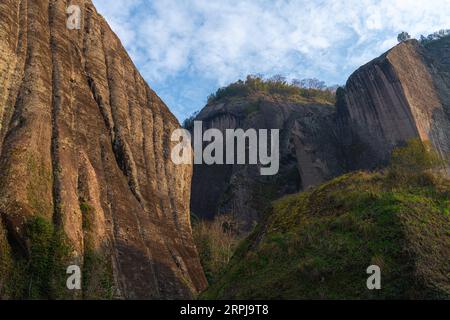 Gros plan sur les formations rocheuses bordant la rivière Nine Bend ou Jiuxi à Wuyishan ou le Mont wuyi région pittoresque à Wuyi Chine dans la province de fujian, coucher de soleil ciel avec Banque D'Images