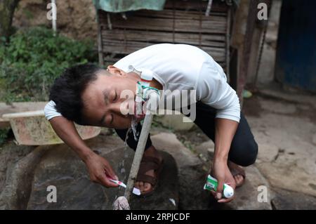 191205 -- CHENGDU, 5 décembre 2019 -- la souris labo se brosse les dents dans le village d'Atulie er, préfecture autonome de Liangshan Yi, province du Sichuan, dans le sud-ouest de la Chine, le 24 novembre 2019. Un garçon nommé Mouse labo a trouvé sa nouvelle vie dans le développement de sa ville natale, Atulie er Village. Le village d'Atulie er est un célèbre village à flanc de falaise dans la préfecture autonome de Liangshan Yi dans le Sichuan. Dans le passé, les villageois ici n'avaient pas accès aux routes. En sortant, ils devaient descendre une falaise de 800 mètres de haut par une échelle en rotin. En 2016, une échelle en acier à 2 556 marches remplace l'échelle à ratten, améliorant considérablement la trave Banque D'Images