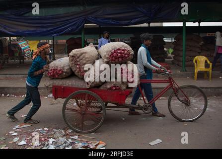 191205 -- NEW DELHI, le 5 décembre 2019 -- des ouvriers transportent des sacs d'oignons avec un pousse-pousse à vélo sur un marché de gros à New Delhi, en Inde, le 5 décembre 2019. Les prix de l'oignon à travers les États indiens continuent de monter en flèche alors que le gouvernement a promis d'importer les bulbes comestibles de pays étrangers. INDE-NEW DELHI-PRIX DE L'OIGNON-FLAMBÉE JAVEDXDAR PUBLICATIONXNOTXINXCHN Banque D'Images
