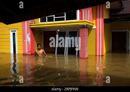 191217 -- RIAU, 17 décembre 2019 -- Un homme marche dans les eaux d'inondation du village de Wisata Buluh Cina dans le district de Kampar, Riau, Indonésie, 17 décembre 2019. Photo de /Xinhua INDONESIA-RIAU-FLOOD AfriantoxSilalahi PUBLICATIONxNOTxINxCHN Banque D'Images