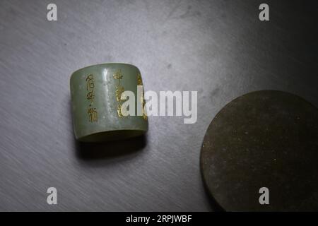 191221 -- PÉKIN, 21 décembre 2019 -- la photo prise le 17 décembre 2019 montre une bague en jade incrustée de caractères en or fabriquée par Guo Weijun à Pékin, capitale de la Chine. En tant que l'un des huit arts et métiers uniques dans l'ancien Pékin, la sculpture de jade a été couronnée comme patrimoine culturel immatériel national en l'an 2008. La technique avec incrustation d'or et d'argent, jouit en particulier d'une réputation de haute art, de valeurs scientifiques et historiques. Guo Weijun, un artisan renommé dans la sculpture de jade incrustée d'or et d'argent, a promu et innové cette technique afin qu'elle puisse être connue et favorisée par plus de peopl Banque D'Images