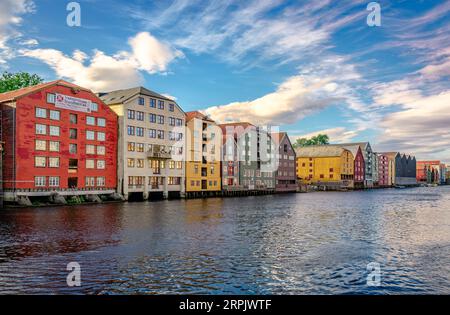 Trondheim, Norvège - août 19 2022 : la rivière Nidelva, avec les entrepôts emblématiques du centre-ville au bord de l'eau par un après-midi ensoleillé. Banque D'Images