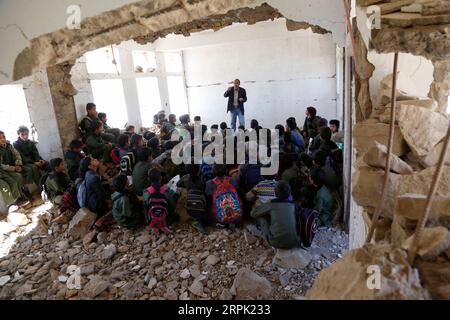 191225 -- IBB, 25 décembre 2019 Xinhua -- des élèves ont une classe à l'école Shuhada-Alwahdah dans le district d'Al-Radhmah dans la province d'Ibb, Yémen, 23 décembre 2019. La guerre au Yémen a forcé plus de deux millions d'enfants à quitter l'école et a mis 3,7 millions d'autres en danger à cause du non-paiement des salaires des enseignants, selon le Fonds des Nations Unies pour l'enfance (UNICEF). Mais pour ceux qui peuvent rentrer, ils risquent tout pour retourner dans les salles de classe, même pour s’asseoir sur les décombres des écoles frappées par des frappes aériennes. POUR ALLER AVEC Feature : les étudiants yéménites retournent à l'école frappée par des frappes aériennes photo par Moham Banque D'Images