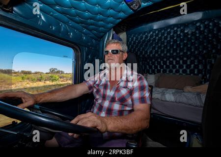 Transport lourd longue distance B-double chauffeur de camion au volant de son camion dans l'outback australien Banque D'Images