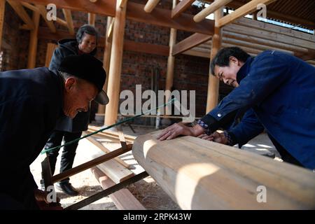 191228 -- NINGHAI, le 28 décembre 2019 -- des artisans ont vu une bûche pour une scène théâtrale traditionnelle au village de Xiafan, dans la ville de Chalu, dans le comté de Ninghai, dans la province du Zhejiang de l est de la Chine, le 27 décembre 2019. Ninghai, connue comme la ville natale de la Chine de la culture théâtrale traditionnelle, possède 125 scènes de ce type, parmi lesquelles 10 sont répertoriés comme unités nationales de protection des reliques culturelles clés. Réparer une scène nécessite une procédure compliquée, qui implique la menuiserie, la sculpture, la peinture en couleur et la maçonnerie. Grâce aux efforts dévoués et au soutien financier du gouvernement local, ces étapes ont retrouvé leur vitalité. Banque D'Images
