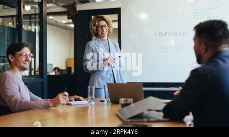 Groupe de professionnels ayant une discussion dans une réunion. femme d'affaires se tient dans une salle de conseil et fait une présentation. Bonne planification de l'équipe d'affaires a Banque D'Images