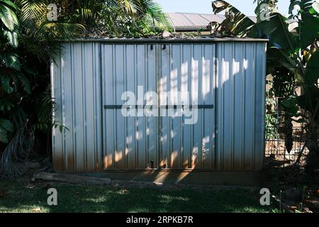 un ancien hangar en étain dans un jardin résidentiel Banque D'Images