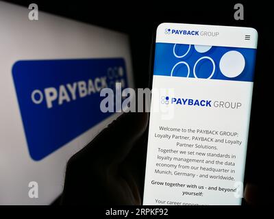 Personne détenant un smartphone avec le site Web de la société allemande de gestion de la fidélité Payback GmbH sur l'écran avec logo. Concentrez-vous sur le centre de l'écran du téléphone. Banque D'Images