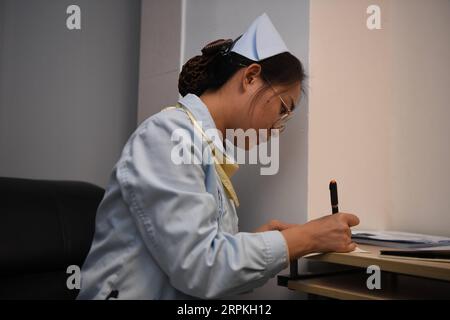 200111 -- CHANGSHA, le 11 janvier 2020 -- Yi Lili, membre du groupe de soins psychologiques, lit le journal d'un patient à l'hôpital du cancer du Hunan à Changsha, dans la province du Hunan du centre de la Chine, le 10 janvier 2020. Un groupe de psychothérapie, de musique et de peinture a servi gratuitement les patients atteints de cancer depuis sa création en 2007 à l'hôpital du Hunan cancer. Xue Yuke CHINA-HUNAN-CHANGSHA-CANCER-PSYCHOLOGY-CARE CN XuexYuge PUBLICATIONxNOTxINxCHN Banque D'Images