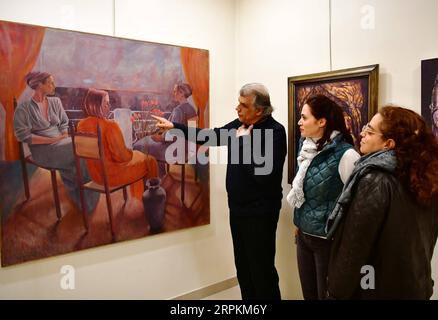 200113 -- DAMAS, le 13 janvier 2020 -- l'artiste syrien Issam Darwish 1st L présente une de ses peintures aux visiteurs de sa galerie à Damas, en Syrie, le 23 décembre 2019. Choqués, s'interrogeant, niant, tristes et incrédules sont les visages qui ont fait leur chemin vers les tableaux de peinture d'Issam Darwish qui reflètent ses sentiments sur son environnement pendant la guerre syrienne. POUR ALLER AVEC la fonction : un peintre syrien dépeint la cruauté de la guerre avec un pinceau photo par /Xinhua SYRIA-DAMASCUS-ARTIST-PAINTING-WAR AmmarxSafarjalani PUBLICATIONxNOTxINxCHN Banque D'Images