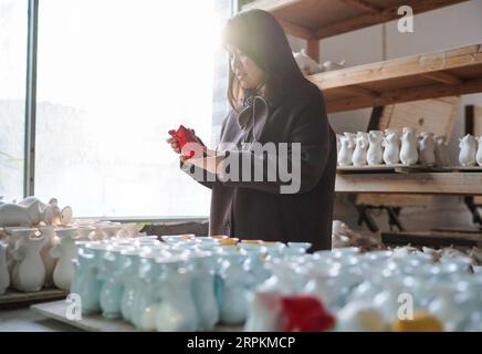 200114 -- JINGDEZHEN, 14 janvier 2020 -- la créatrice de porcelaine Wu Anran vérifie les produits conçus par elle qui présente l'année chinoise du rat à Jingdezhen, dans la province de Jiangxi de l'est de la Chine, le 8 janvier 2020. Jingdezhen, également connue sous le nom de capitale de la porcelaine , est célèbre pour son savoir-faire en céramique élaboré qui nécessite un processus de production extrêmement compliqué. Dans le passé, de nombreux designers de porcelaine jeunes, compétents et ambitieux pouvaient créer de bons designs, mais avaient du mal à compléter indépendamment la production et les ventes. D'autre part, les entreprises traditionnelles qui pourraient faire de la production Banque D'Images