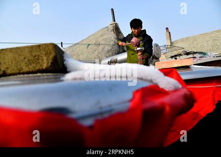 200115 -- RONGCHENG, le 15 janvier 2020 -- Yu Haiyang conserve de la sauce aux crevettes dans le village de Yandunjiao de Rongcheng, dans la province du Shandong de l'est de la Chine, le 12 janvier 2020. Yandunjiao, un village côtier dans le Shandong, est plein de vitalité car de nombreux cygnes hivernent ici. À la fin de 2014, le service de train à grande vitesse entre Qingdao et Rongcheng a été lancé et de nombreux touristes sont venus ici pour voir des cygnes, déguster des spécialités locales et faire l'expérience d'un séjour chez l'habitant dans des maisons aux toits d'algues. Yu Haiyang, un villageois natif qui a travaillé à Singapour après l'obtention de son diplôme, est retourné dans sa ville natale et a commencé une entreprise chez l'habitant avec son papillon Banque D'Images