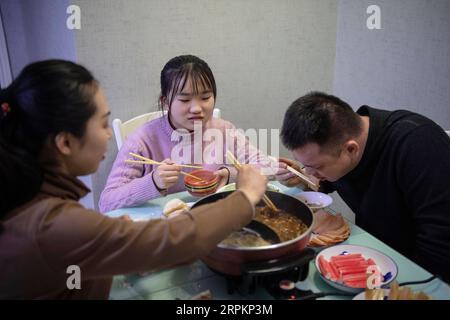 200115 -- TAIYUAN, 15 janvier 2020 -- le couple Zhao Yao R et Chen Haiyan L dînent avec leur fille Zhao Chunyi à la maison à Taiyuan, dans la province du Shanxi du nord de la Chine, le 14 janvier 2020. Alors que des millions de Chinois rentrent chez eux pour rattraper la veille de la fête du printemps, le nouvel an lunaire chinois, Zhao Yao et Chen Haiyan, un couple travaillant tous les deux comme chefs d orchestre dans les trains, vont rater l anniversaire de leur fille qui tombe le même jour de la veille, aussi l'occasion la plus importante de réunion de famille pour les Chinois. Il n'y a que trois fois pour le couple de passer l'anniversaire avec leur fille depuis elle Banque D'Images