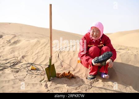 200116 -- XAYAR , le 16 janvier 2020 -- Chen Liyun enlève du sable de sa chaussure pendant sa pause de travail dans le désert de Taklimakan, dans la région autonome ouïgoure du Xinjiang, au nord-ouest de la Chine, le 14 janvier 2020. Les travailleurs de l'exploration pétrolière de BGP Inc., China National Petroleum Corporation, dont plus de 60 femmes, travaillent dur dans le désert de Taklimakan. CHINE-XINJIANG-TAKLIMAKAN DESERT-OIL TRAVAILLEUR CN DINGXLEI PUBLICATIONXNOTXINXCHN Banque D'Images