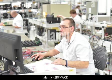 En micro-électronique de l'ingénierie : les travailleurs dans la production et l'assemblage de composants électroniques de haute technologie dans une usine moderne Banque D'Images