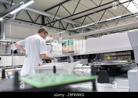 En micro-électronique de l'ingénierie : les travailleurs dans la production et l'assemblage de composants électroniques de haute technologie dans une usine moderne Banque D'Images